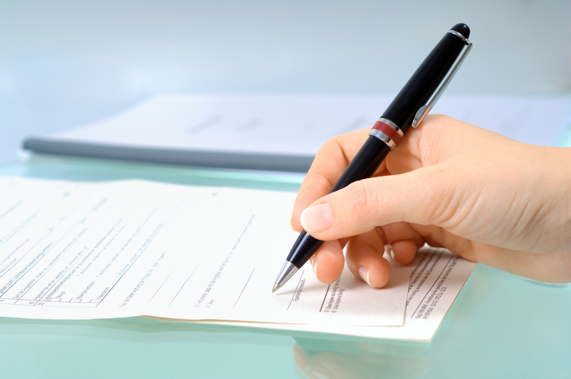 Signature Hand with black pen signs a form.