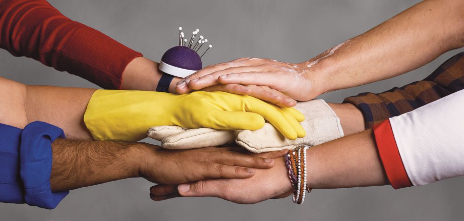 Different hands on top of each other and cubes with white lettering "Stark. Social. On site.".