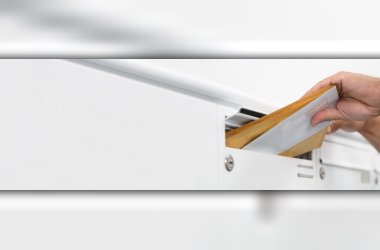 Letter is pushed into the slot of a white letterbox.