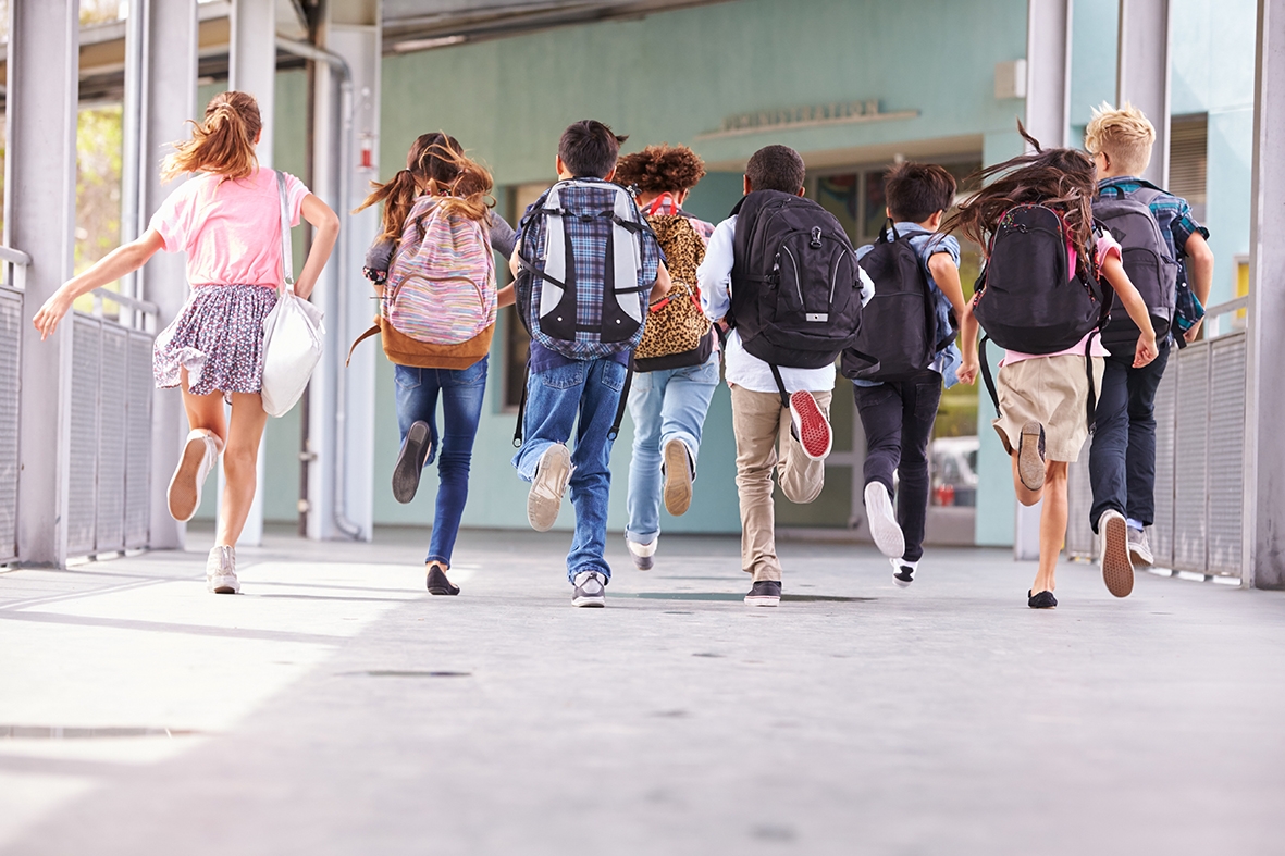 Grupo de alumnos caminando por el pasillo de la escuela.