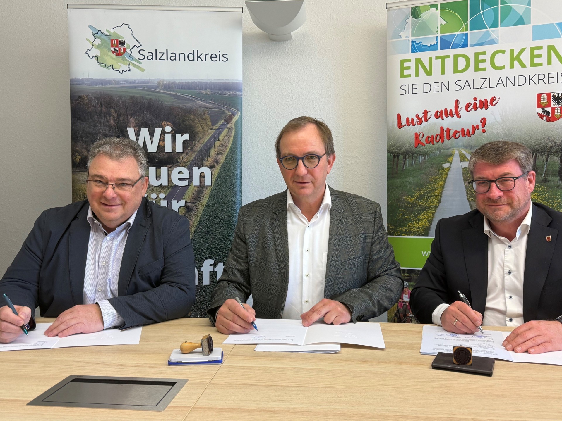 El alcalde de Güsten, Michael Kruse (izquierda), el administrador del distrito, Markus Bauer, y el alcalde de Schönebeck, Bert Knoblauch, durante la firma de los acuerdos en la oficina de administración del distrito en Bernburg.