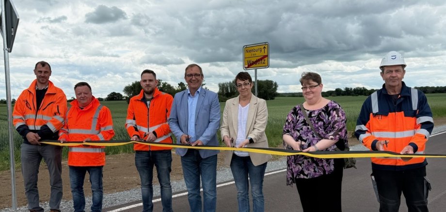 Le Landrat Markus Bauer (4ème à partir de la gauche) et la maire de Nienburg Susann Falke (5ème à partir de la gauche) lors de l'ouverture officielle de la route départementale 2101 près de Wedlitz. On peut également voir d'autres personnes impliquées dans la rénovation.