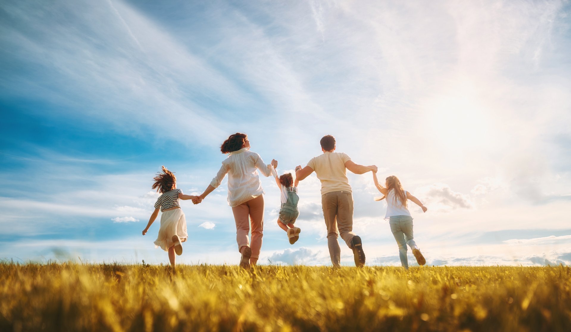 Une famille heureuse lors d'une promenade estivale ! La mère, le père et les filles se promènent dans le parc et profitent de la belle nature.