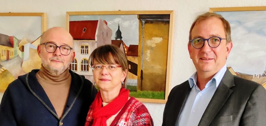 Das Foto zeigt (v. l.) Annekatrin Lutze mit ihrem Mann Ingolf neben Markus Bauer, nachdem die Bilder der kleinen Ausstellung im Landratsamt nach den Vorstellungen der Freizeitkünstlerin gehängt und ausgerichtet wurden. Das Foto zeigt (v. l.) Annekatrin Lutze mit ihrem Mann Ingolf neben Markus Bauer, nachdem die Bilder der kleinen Ausstellung im Landratsamt nach den Vorstellungen der Freizeitkünstlerin gehängt und ausgerichtet wurden.