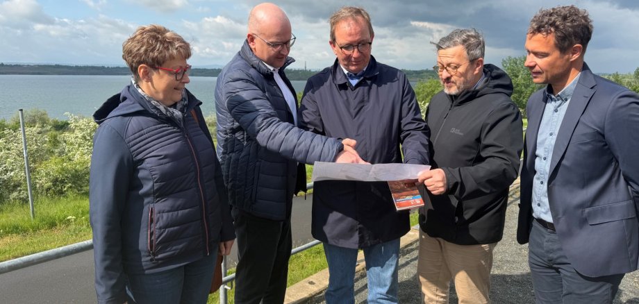 An der Seepromenade in Schadeleben sprach Landrat Markus Bauer über die neuen Möglichkeiten beim R1-Ausbau mit Bürgermeister Robert Käsebier, René Walliser, Geschäftsführer der Seeland GmbH, Detlef Gürth, Landtagsabgeordneter, und Evelyn Wolter vom Fachdienst Kreis- und Wirtschaftsentwicklung und Tourismus.