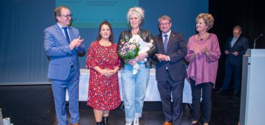 v.l.n.r.: Herr Markus Bauer, Landrat Salzlandkreis; Frau Dorothée Vatterott, Mitarbeiterin Marketing/Öffentlichkeitsarbeit Stadtwerke Schönebeck GmbH; Frau Sandy Schützmannsky, Ehrenpreisträgerin; Herr Bert Knoblauch, Oberbürgermeister Stadt Schönebeck (Elbe); Frau Andrea Alzuro Lopez, Gleichstellungsbeauftragte Stadt Schönebeck (Elbe); im Hintergrund: Herr Frank Sieweck, Moderator der Ehrungsveranstaltung (Kommunalmanagement/Pressesprecher EMS Energie Mittelsachsen GmbH)