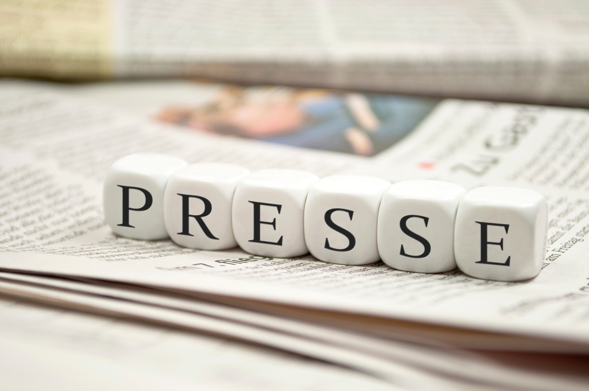 Schriftzug "Presse" mit Zeitungen im Hintergrund