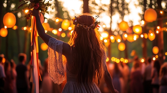 A woman in a flower crown raising ribbons at a lantern-lit festival in the woods A woman in a flower crown raising ribbons at a lantern-lit festival in the woods